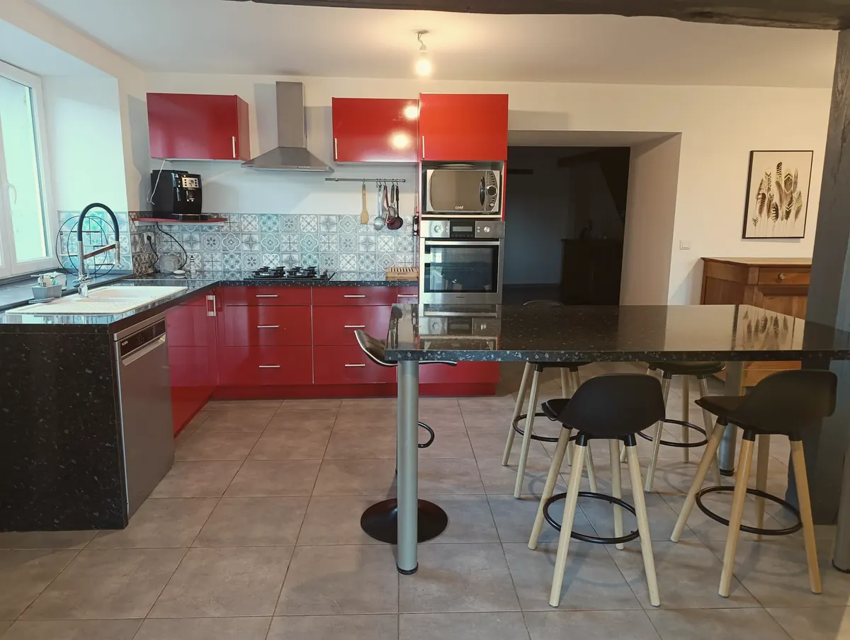 La cuisine équipée et son grand îlot entouré de tabourets
