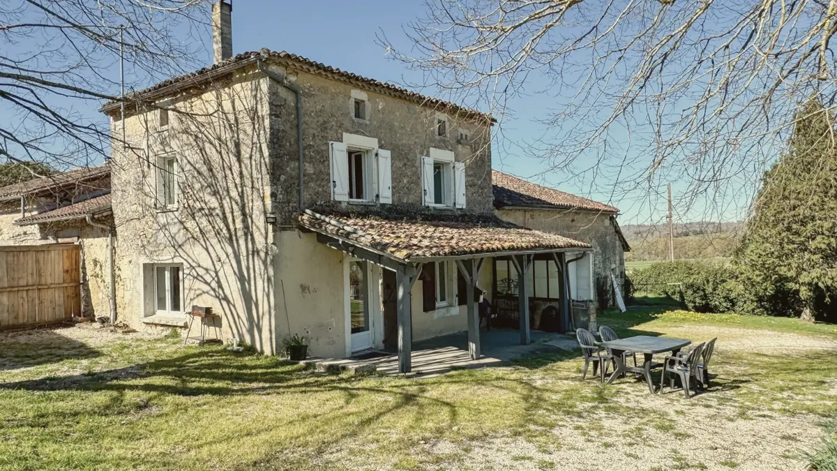 La façade en pierre et la terrasse couverte au printemps